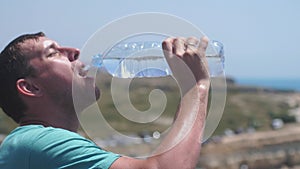 Handsome man drinking water during break in running, slow motion. 3840x2160