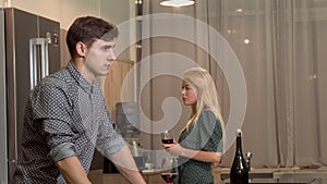 Handsome man drinking wine after having a fight with his girlfriend at home