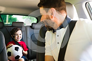 Handsome man driving his cute son to class