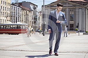 Handsome man elegantly dressed looking at his watch