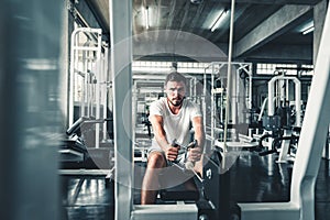 Handsome Man is Exercising With Bodybuilder Machine in Fitness Club.,Portrait of Strong Sporty Man Doing Working Out Calories Burn