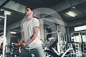 Handsome Man is Exercising With Bodybuilder Pulling Machine in Fitness Club.,Portrait of Strong Sport Man Doing Working Out Muscle