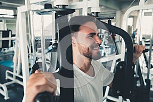 Handsome Man is Exercising With Pectoral Machine in Fitness Club.,Portrait of Strong Man Doing Working Out Calories Burning in Gym photo