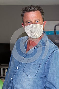 Handsome man with face mask homemade in home quarantine lockdown covid-19 corona virus pandemic contagious disease