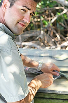 Handsome man filleting a fish vertical photo