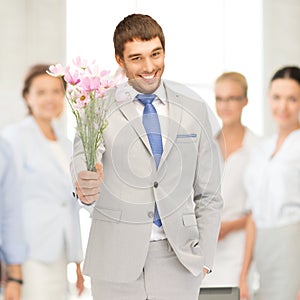 Handsome man with flowers in hand