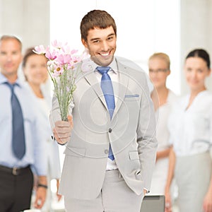 Handsome man with flowers in hand