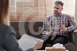 Handsome man gesticulating while talking to his psychologist during a therapy