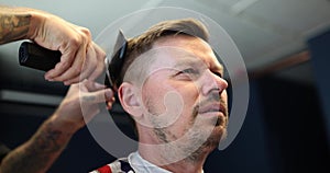 Handsome man gets his hair cut at barbershop