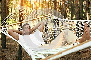 Handsome man resting in hammock outdoors on summer day