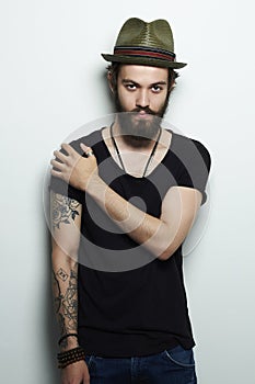 Handsome man in hat.Brutal bearded boy with tattoo