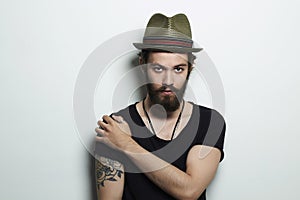 Handsome man in hat.Brutal bearded boy with tattoo photo