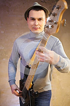 Handsome man in a hat holding an electric guitar