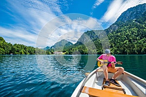 A handsome man is is having a genuine beautiful moment on a little boat in the lake