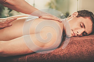 Handsome man having massage in spa salon