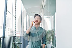 Handsome man having serious conversation on cell phone outside on balcony