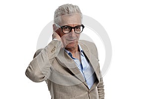 handsome man in his 60s with glasses holding hand behind neck