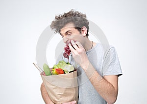 Handsome man holding a bag full of groceries