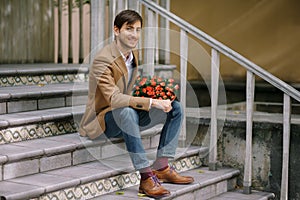 Handsome man holding bouquet of roses smiling happy