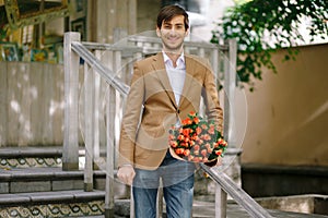 Handsome man holding bouquet of roses talking happy on phone
