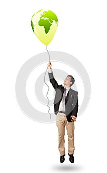 Handsome man holding a green globe balloon