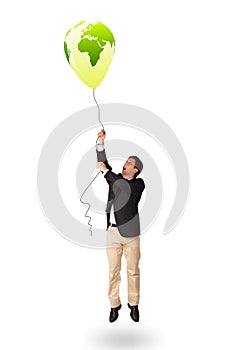 Handsome man holding a green globe balloon