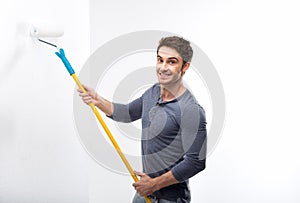 Handsome man holding paint roller and isolated on white