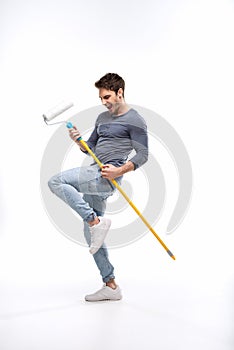 Handsome man holding paint roller isolated on white