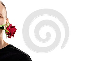 Handsome man holding red rose in mouth isolated on white. Copy space