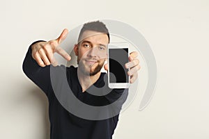 Handsome man holding smartphone in studio