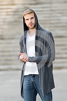 Handsome man with hood standing in urban city interior. informal style clothing. Fashionable young model man. Mystery