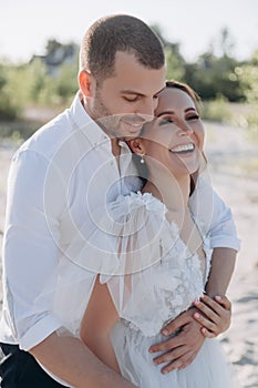 handsome man hugging his laughing girlfriend
