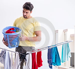 Handsome man husband doing laundering at home