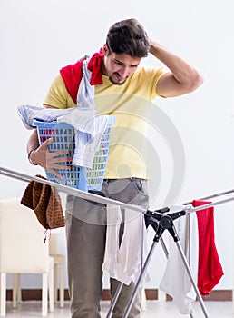 Handsome man husband doing laundering at home