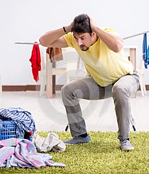 Handsome man husband doing laundering at home