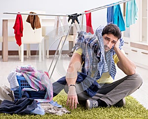 Handsome man husband doing laundering at home