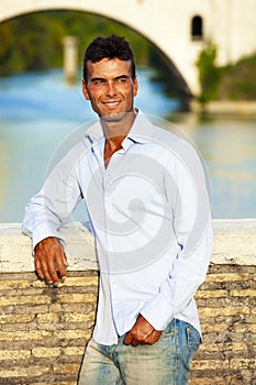 Handsome man Italian outdoors in Rome Italy. Tiber river and bridge