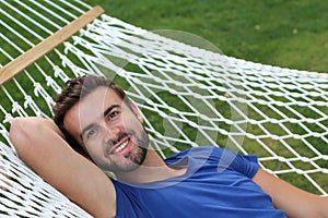 Handsome man laying in hammock and smiling