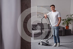 handsome man leaning on vacuum cleaner