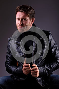 Handsome man in leather jacket seated