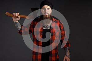 Handsome man with long hair with an ax in his hands on a dark studio background