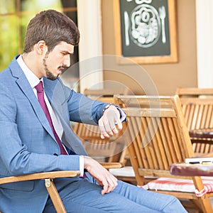 Handsome man looking time at watch
