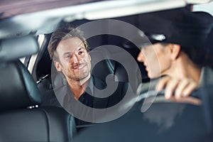 Handsome man in luxury car smiling