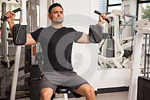 Handsome man on a pec deck machine