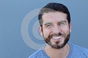 Handsome man with perfect white smile on blue background with copy space