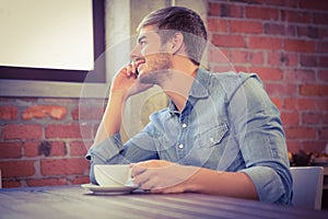 Handsome man phoning and looking out of window