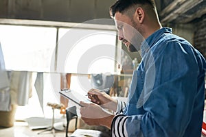 Handsome man planning project in workshop