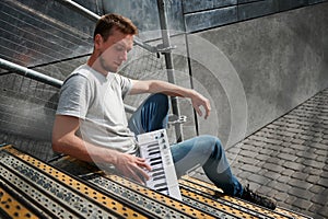 Handsome man playing on digital piano.