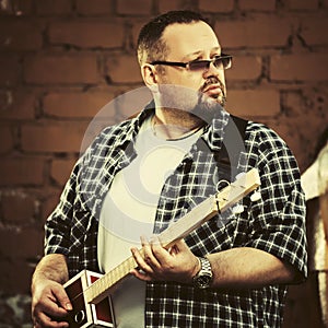 Handsome man playing his cigar box guitar