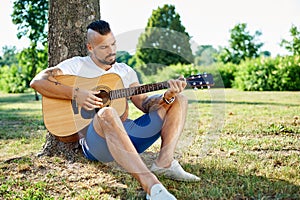 Handsome man plying guitar outdoor photo